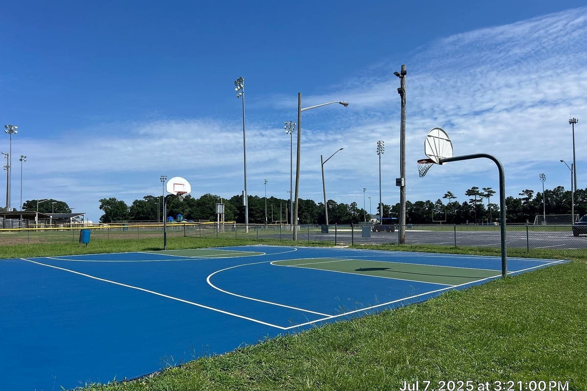 Finished blue and green public basketball courts under light poles with fresh white lines — Cedar Point, NC