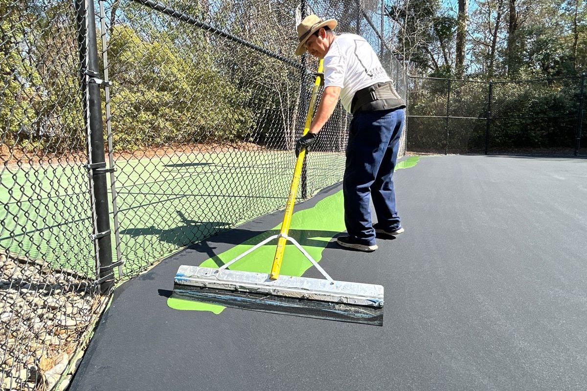 Service illustration: two new pickleball courts with regulation lines being finished by installers